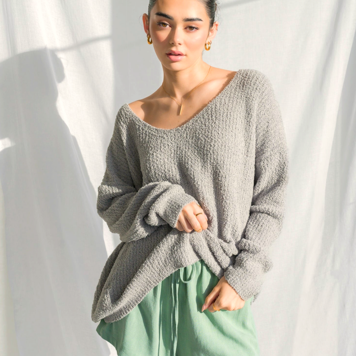 Model wearing OKAKIE oversized charcoal grey fuzzy teddy bear sweater with V-neck and drop shoulders