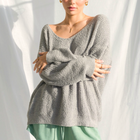 OKAKIE model wearing an oversized charcoal grey fuzzy teddy bear sweater with a V-neck and drop shoulder sleeves.