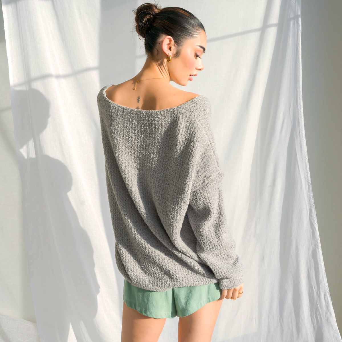 OKAKIE oversized charcoal grey fuzzy teddy bear sweater with V-neck and drop shoulders worn by a model