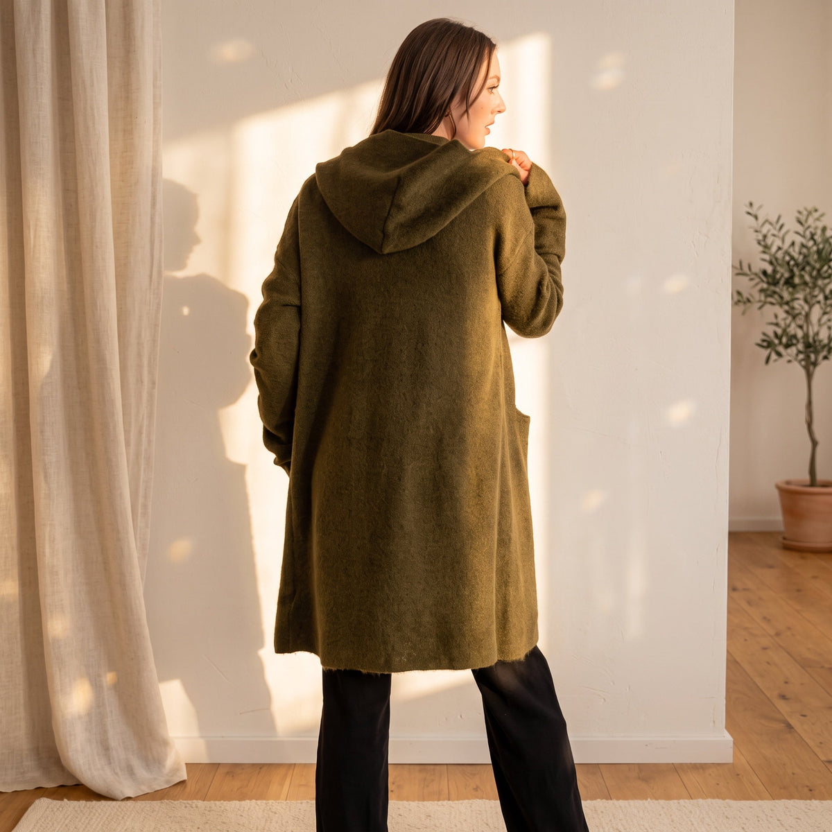 OKAKIE Adrienne heavyweight olive hooded cardigan with oversized hood and patch pockets worn by a woman