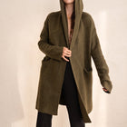 OKAKIE Adrienne heavyweight olive green hooded cardigan with an open front, long sleeves, and deep patch pockets.