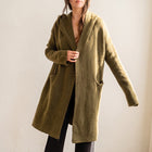 OKAKIE Adrienne heavyweight olive hooded cardigan with an open-front design, dropped shoulders, and patch pockets.