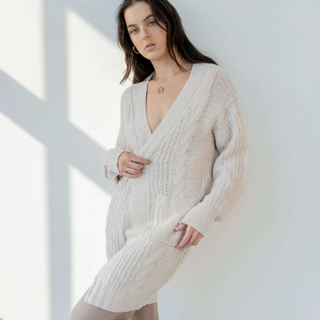 OKAKIE beige cable knit cardigan with a collarless design, drop shoulders, and patch pockets on a model