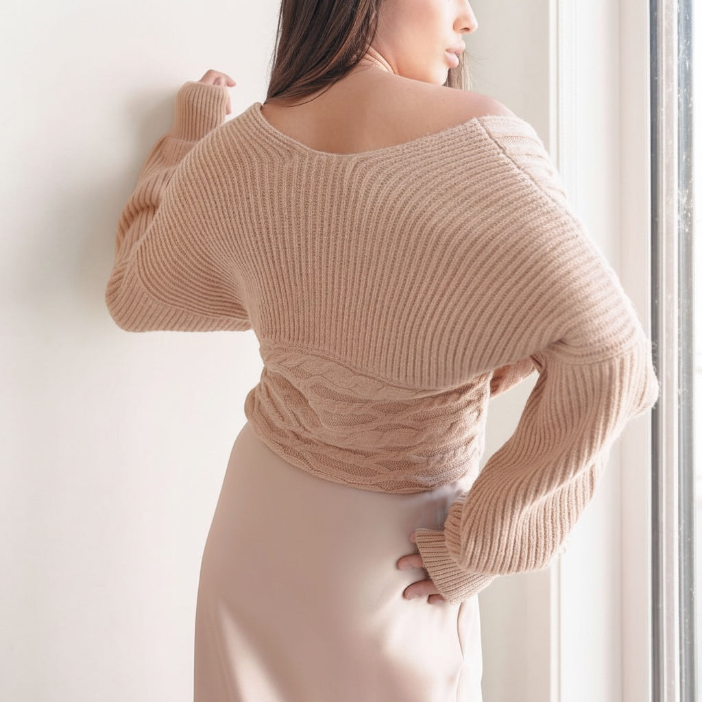 OKAKIE beige cable knit sweater with an off-shoulder design and wide dolman sleeves worn by a model