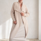 OKAKIE beige heavy knit coatigan with oversized lapel, drop shoulders, and patch pockets worn over a matching dress.