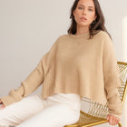 OKAKIE beige oversized purl knit cropped sweater with crew neckline and drop shoulders worn by a model