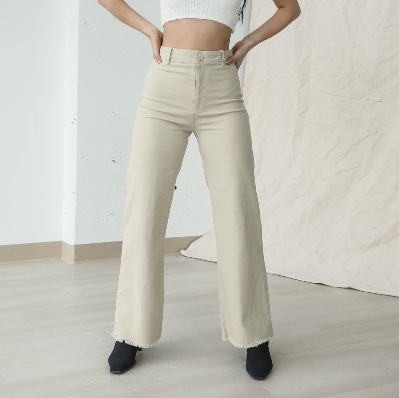 OKAKIE beige stretch cotton pants featuring a mid-rise waist, subtle bootcut leg, and a relaxed raw-cut frayed hem.