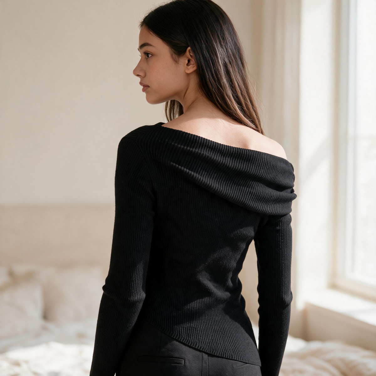 OKAKIE black asymmetric draped sweater top with long sleeves and ribbed knit texture worn by a woman