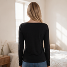 Back view of a woman wearing an OKAKIE black long-sleeve boat neck top with a soft brushed ribbed knit texture.