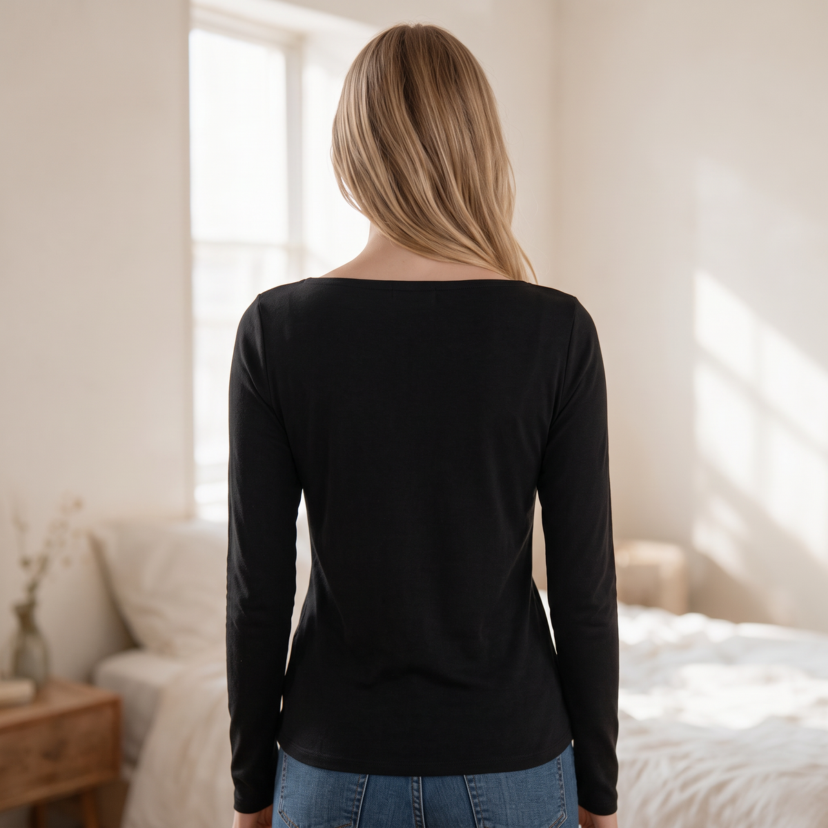 Back view of a woman wearing an OKAKIE black long-sleeve boat neck top with a soft brushed ribbed knit texture.