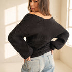 OKAKIE black cable knit sweater with wide dolman sleeves and off-shoulder neckline worn by a model