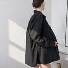 OKAKIE black cotton poplin boyfriend over-shirt with side slits and button-up front worn by a model