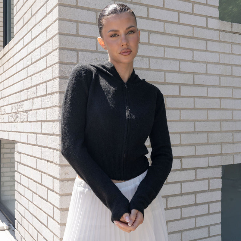 OKAKIE black cotton-rich knit zip hoodie with a clean silhouette and ribbed hem worn by a model outdoors