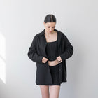 OKAKIE black cotton poplin boyfriend over-shirt worn open over a matching black corset top and mini skirt