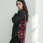 Model wearing OKAKIE black cotton shacket with Southwestern-inspired red and orange patterned back panel