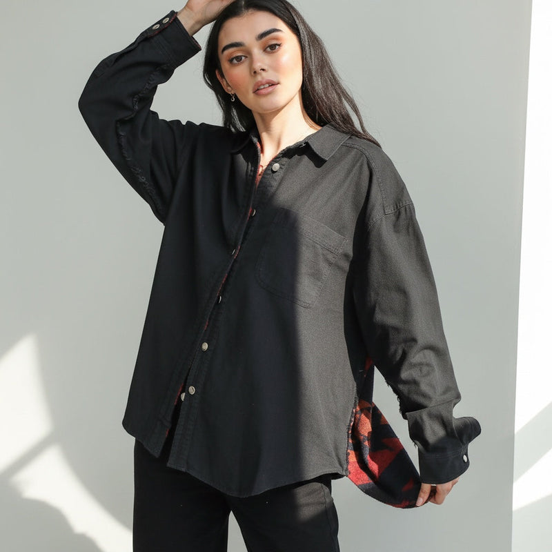 Model wearing an OKAKIE black cotton reversible shacket with Southwestern-inspired patterned lining and snap buttons.