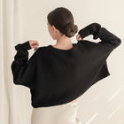 OKAKIE black oversized purl knit cropped sweater with drop shoulders and crew neckline, back view on a model.