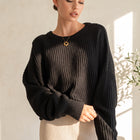OKAKIE black oversized purl knit sweater with crew neckline and drop shoulder sleeves on a model