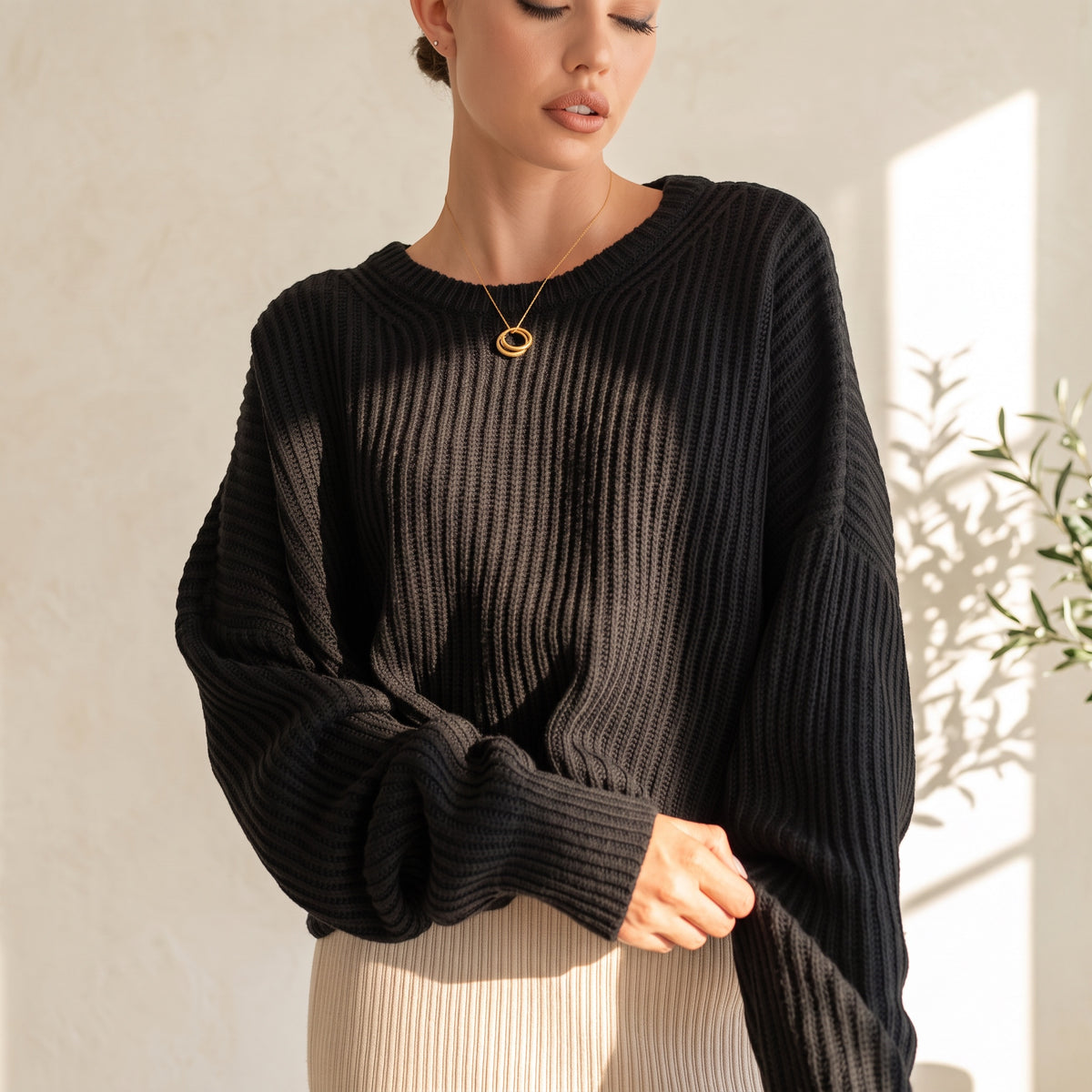 OKAKIE black oversized purl knit sweater with crew neckline and drop shoulder sleeves on a model