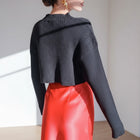 OKAKIE black ribbed crop sweater with high neckline and long sleeves worn with a red skirt