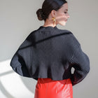 OKAKIE black ribbed crop sweater with high neckline and long sleeves worn by a model in a studio setting