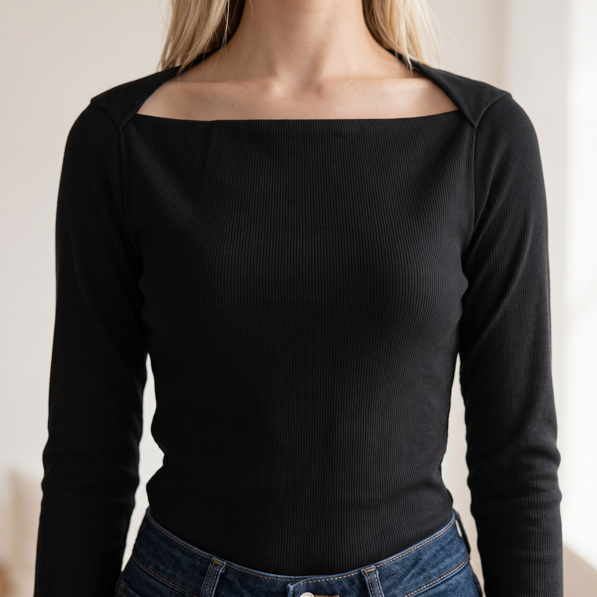 OKAKIE black long-sleeve rib knit top with a square neckline and fitted silhouette worn with blue denim jeans.