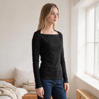 OKAKIE black long sleeve rib knit top with a square neckline worn by a blonde model in a bright bedroom.