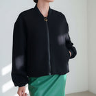 OKAKIE Renée structured black bomber jacket with a collarless neckline, full zip, and voluminous sleeves.