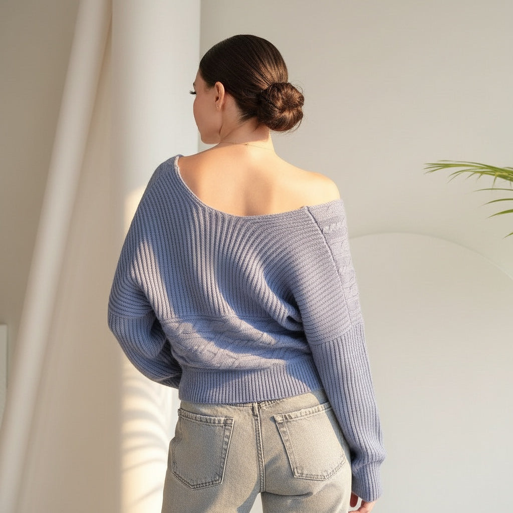 OKAKIE blue cable knit sweater with an off-shoulder design and wide dolman sleeves worn by a woman from the back