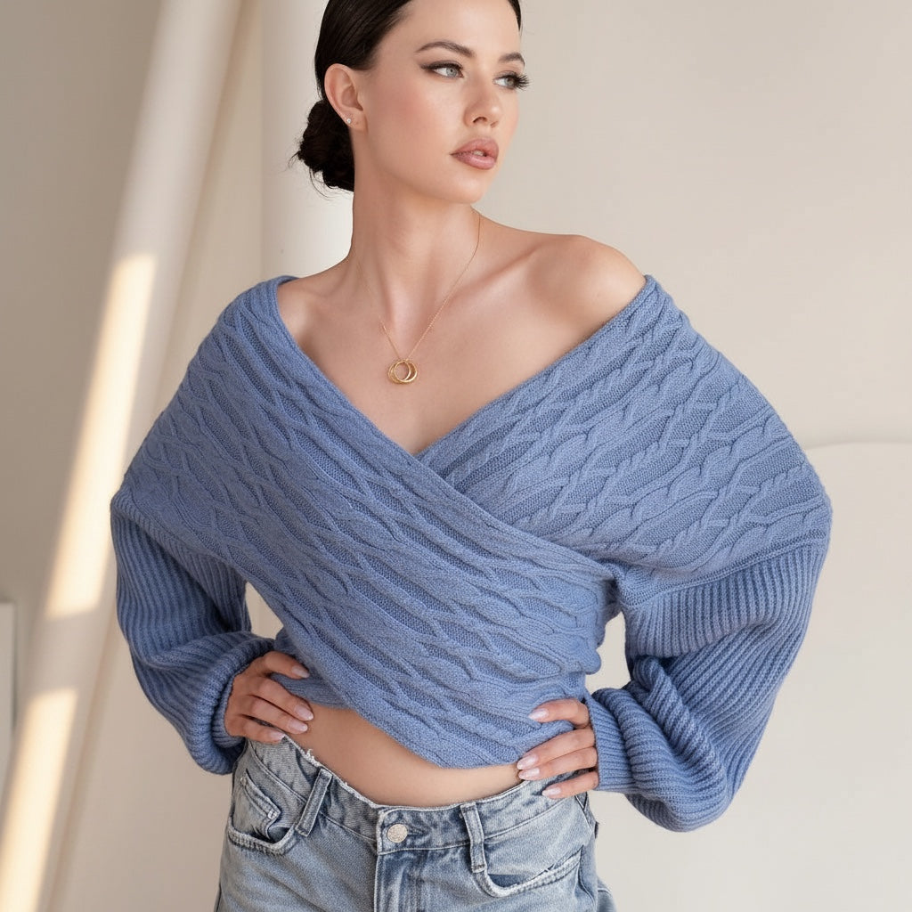 OKAKIE blue cable knit sweater with a criss cross off-shoulder design and wide dolman sleeves worn by a model