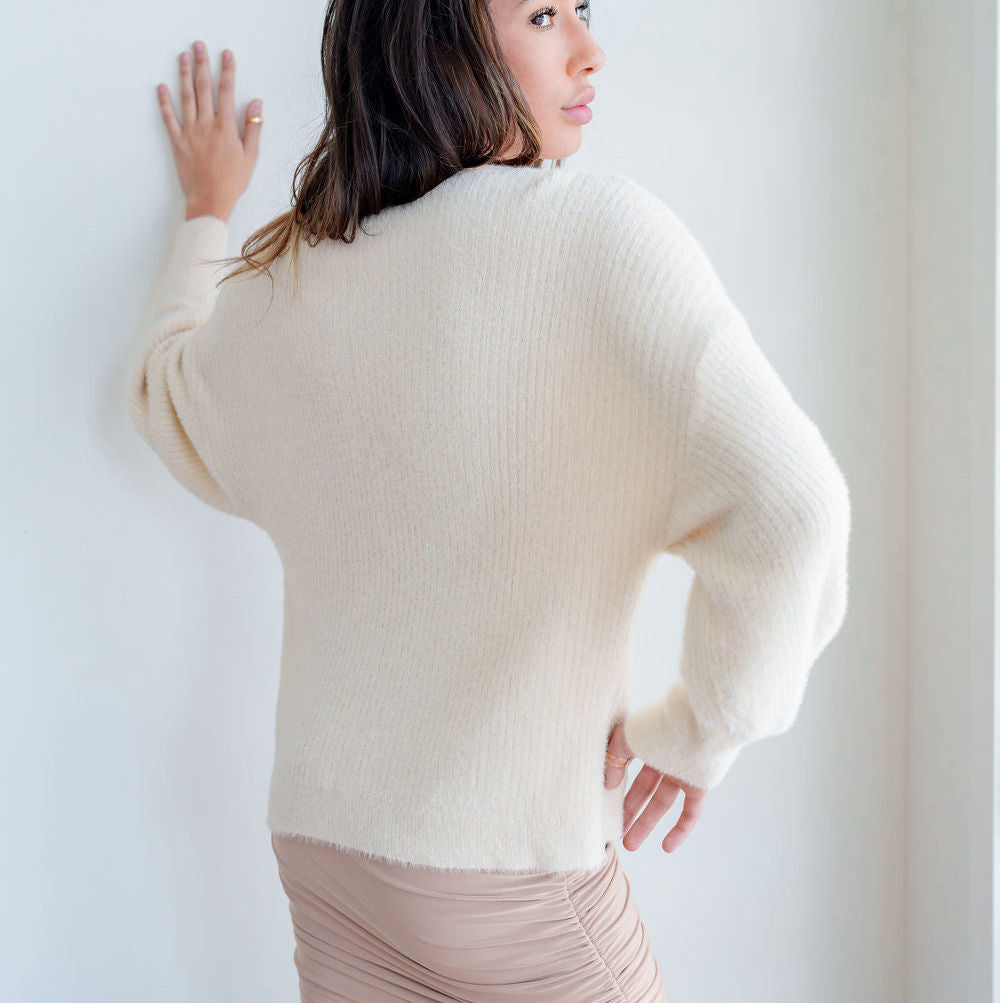 OKAKIE fuzzy blush mock-neck tunic with voluminous sleeves and dropped shoulders worn by a model, back view.