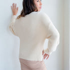 OKAKIE fuzzy blush mock-neck tunic with voluminous sleeves and dropped shoulders worn by a model, back view.