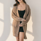 OKAKIE medium weight cable knit cardigan in brown with oversized patch pockets and drop shoulder sleeves.