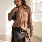 OKAKIE brown fuzzy V-neck button-up cardigan with ribbed texture, worn by a model with a black skirt.