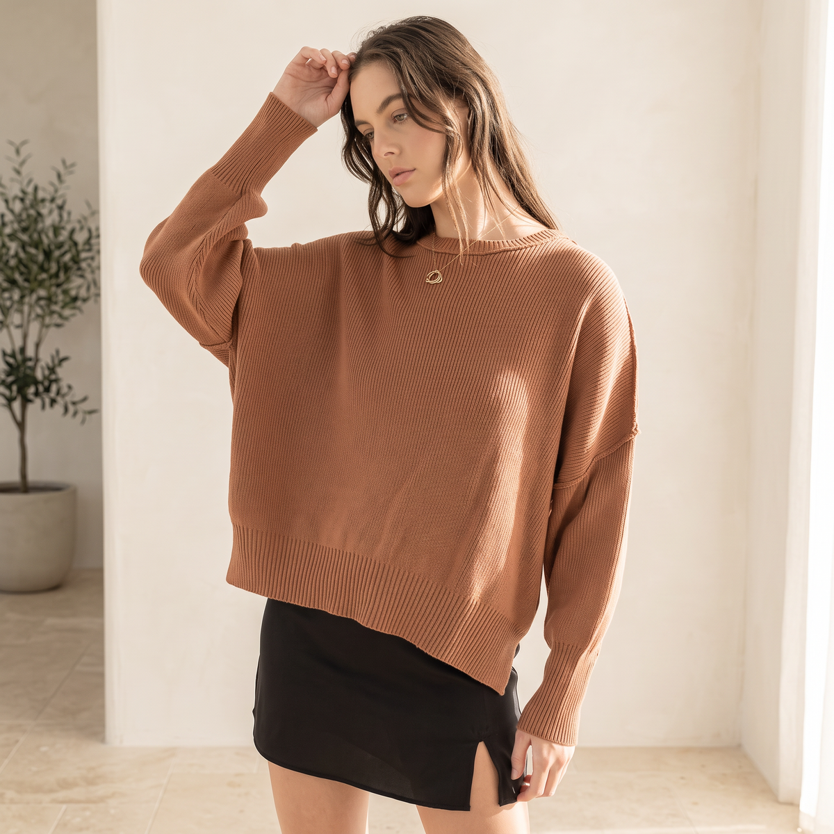 OKAKIE model wearing a brown oversized boyfriend cotton sweater with drop shoulders and micro ribbed texture