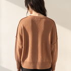 Back view of OKAKIE oversized boyfriend cotton sweater in brown with micro ribbed texture and drop shoulder design.