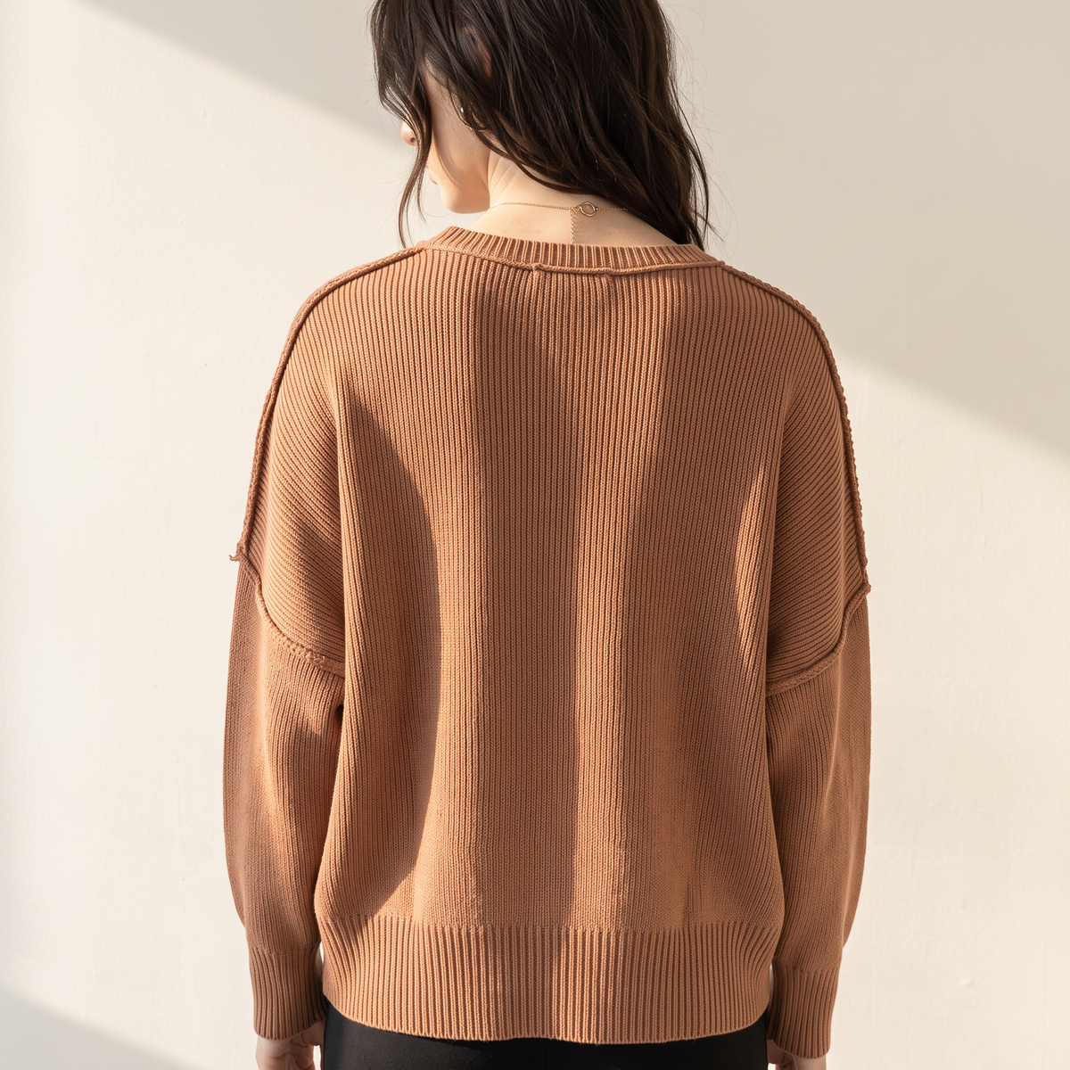 Back view of OKAKIE oversized boyfriend cotton sweater in brown with micro ribbed texture and drop shoulder design.