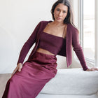 OKAKIE burgundy fuzzy knit two-piece set featuring a cropped tank and bolero cardigan worn by a woman on a sofa.