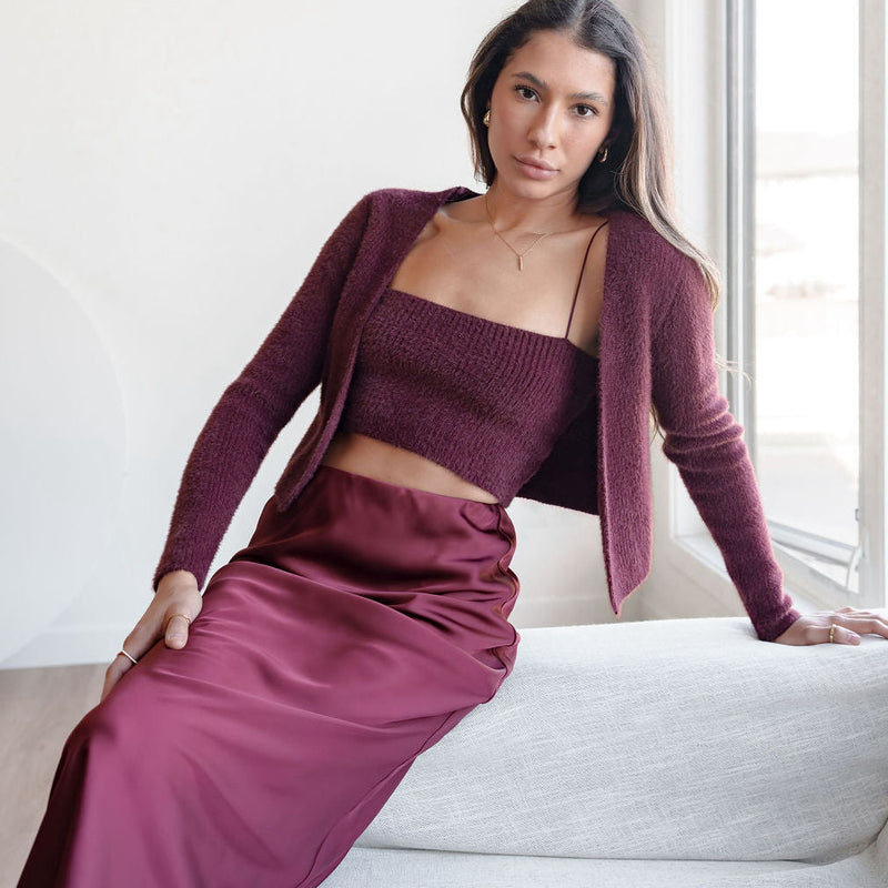 OKAKIE burgundy fuzzy knit two-piece set featuring a cropped tank and bolero cardigan worn by a woman on a sofa.