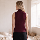 OKAKIE burgundy sleeveless high neck rib knit top with curved detailing worn by a woman in a bright room