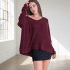 Model wearing an OKAKIE burgundy heavy cotton tunic with a wide V-neck, drop shoulders, and a speckled knit texture.