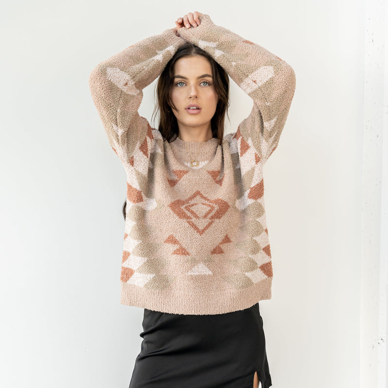 Model wearing an OKAKIE plush knit sweater with a neutral geometric cabin pattern, crew neck, and oversized fit.