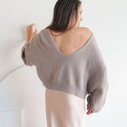 OKAKIE The Célene reversible sweater in taupe featuring a dramatic low-back, relaxed fit, and soft viscose-blend knit.