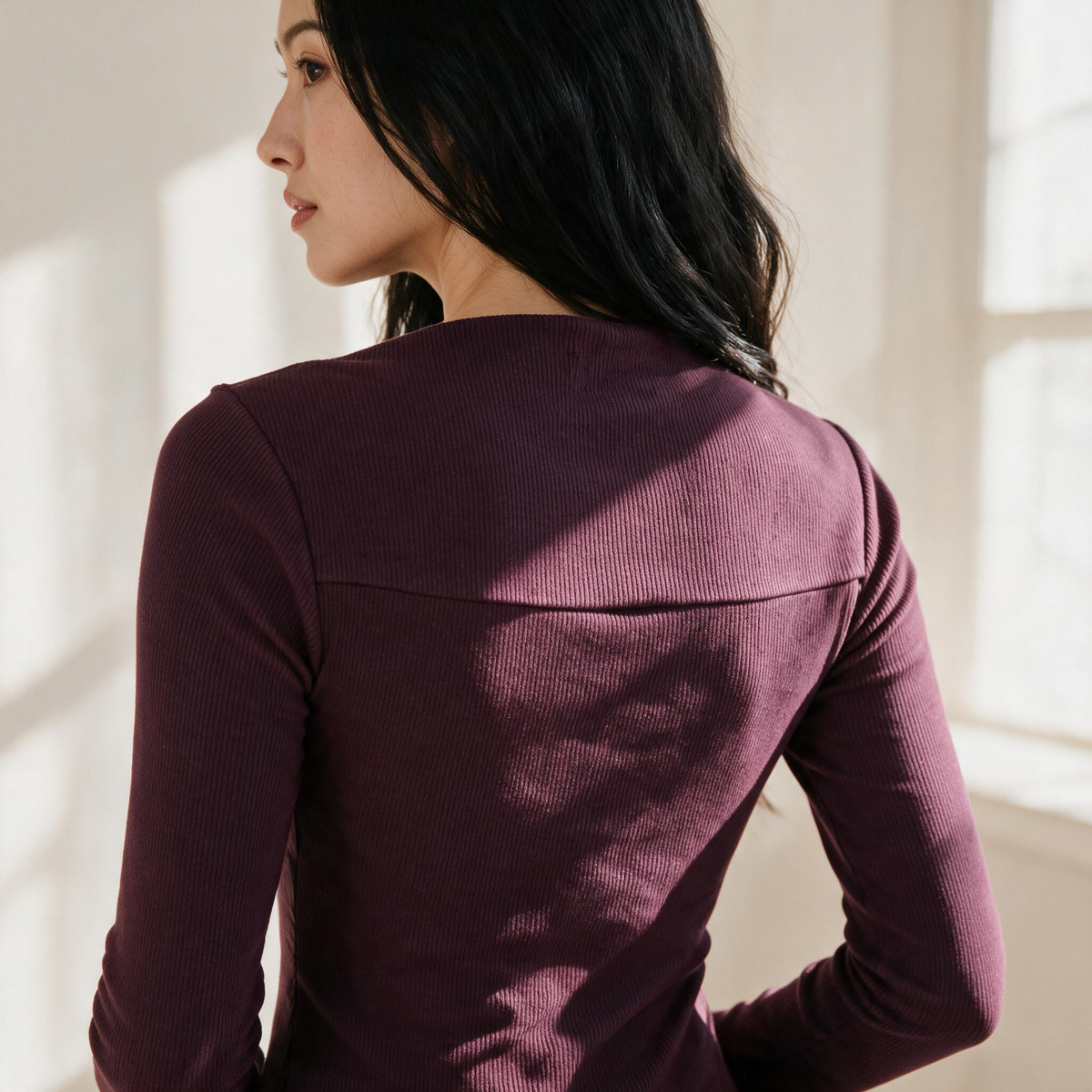 OKAKIE Céleste long sleeve rib knit top in deep plum with a square neckline and fitted silhouette on a model