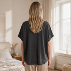 Back view of a woman wearing an OKAKIE charcoal grey oversized raw cotton tee with a textured slub finish.