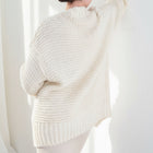 OKAKIE cream heavy knit cardigan with a thick purl texture, dolman sleeves, and an oversized fit, back view.