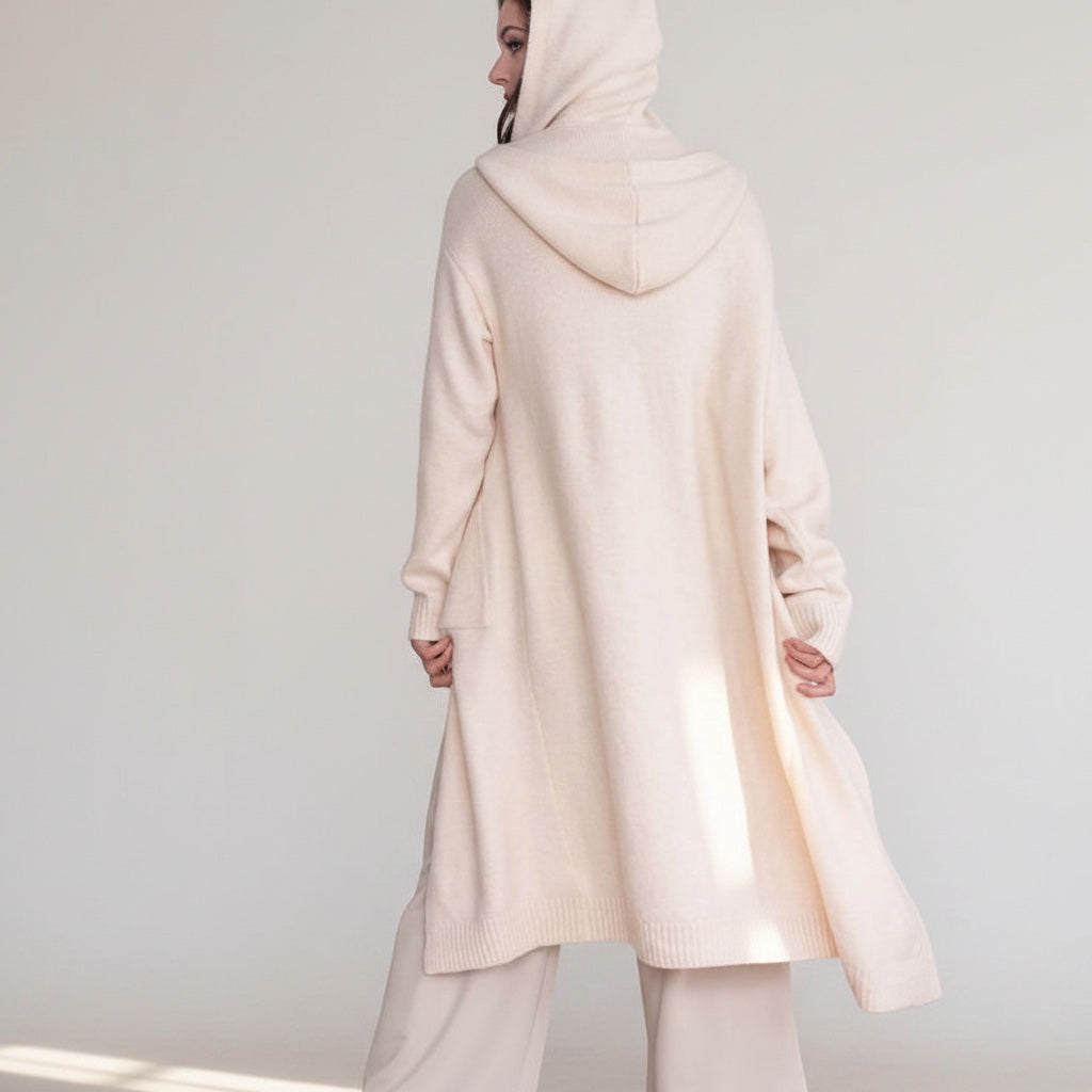 OKAKIE cream hooded maxi cardigan with thick purl knit texture, oversized fit, and patch pockets on a model