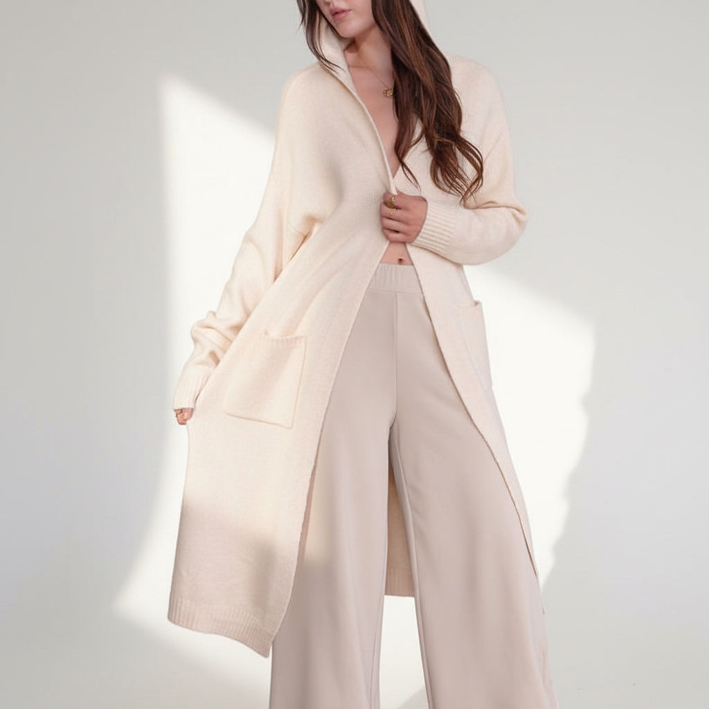 OKAKIE cream hooded maxi cardigan in a thick purl knit with oversized patch pockets and long sleeves on a model.