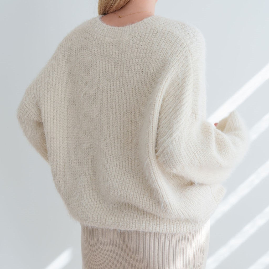 Back view of an OKAKIE cream-colored mohair tunic sweater with a relaxed fit, dropped shoulders, and fuzzy texture.