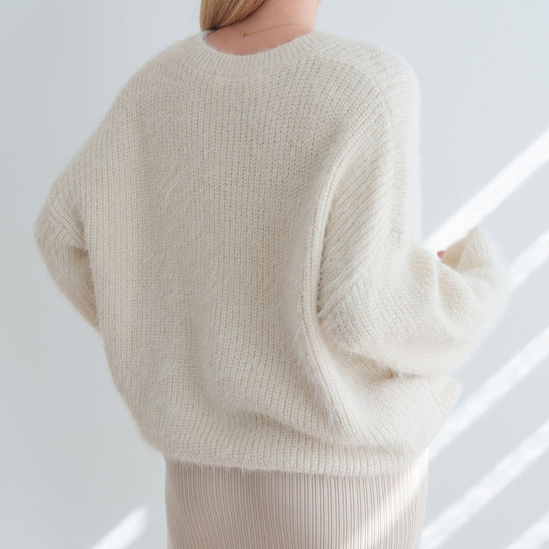 Back view of an OKAKIE cream-colored mohair tunic sweater with a relaxed fit, dropped shoulders, and fuzzy texture.